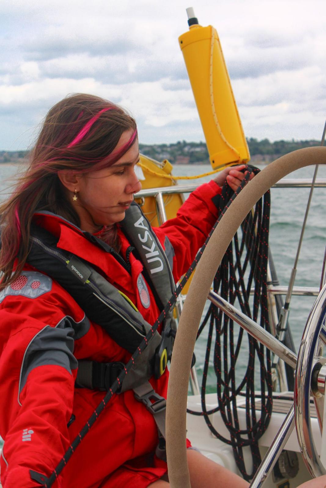 Zehra at the wheel in a red life jacket.